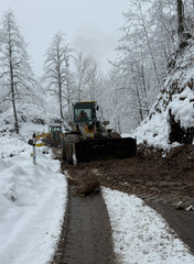 A powerful machine battles winter’s aftermath, carving a path through the frozen wilderness