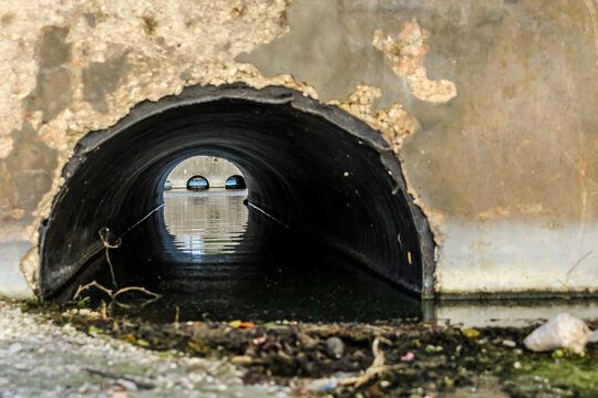 close-up of an old culvert system under a roadway to help prevent water from pooling. tunnel structure to assist with stormwater drainage