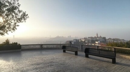Fototapeta premium Serene Cityscape View from Park Overlook Benches Foggy Sunrise