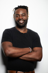 Portrait of a confident Black man with well-groomed beard wearing a denim shirt against a white background