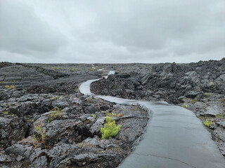 Trail curves through lava fields to caves; evokes sense of another world.
