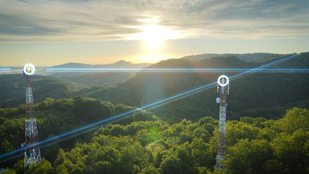 3D graphic overlay on 5G communication towers in a green forest at sunrise. High-speed connectivity and digital network expansion concept - Powered by Adobe
