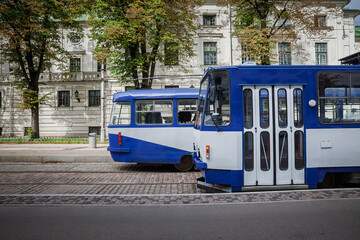 Blue trams operating on city streets of Riga, Latvia, highlighting urban public transportation.
