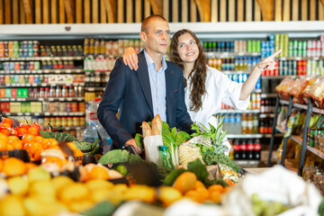 Portrait of a happy young man and girl in a supermarket, who came to shop