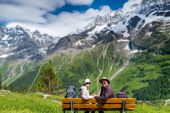 Switzerland Travel - Senior Couple enjoy the Scenic view of the snowcapped mountains in the Jungfrau region of Lauterbrunnen  Swiss Alps