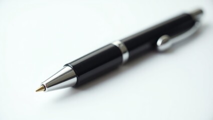 Used metallic black ballpoint pen, isolated against a white background, close-up texture.
