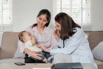 Obraz premium Pediatrician interacting with a mother and baby during a home visit, promoting child health and family care.