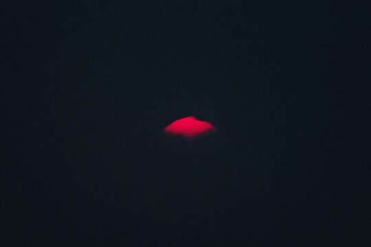 Black white sky with only a single glowing pink sunset cloud adding warmth