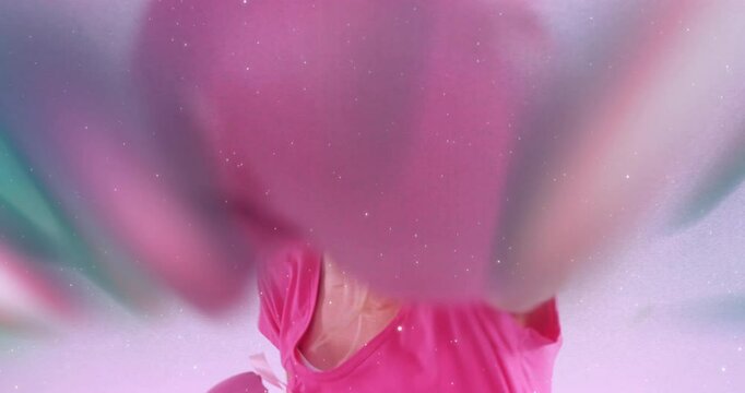 Wearing pink shirt, person creating animation with colorful, blurred motion effect