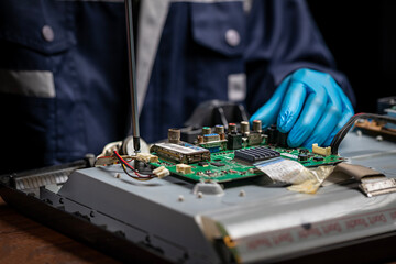Repairman fixing an LCD TV circuit board on table. Close up, electronic device