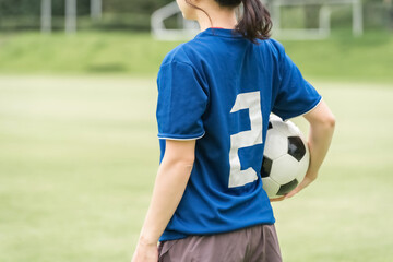 サッカーボールを持ちながら応援するファン・サポーターの日本人女性
