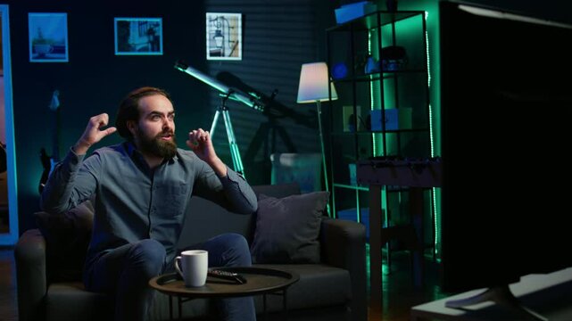 Furious sports fan in disbelief during match broadcast after own team fails to score, expressing anger. Enraged man acting childish in frustration after seeing favorite club commit blunder, camera B