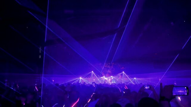 gente bailando en un club nocturno con espect&aacute;culo de laser