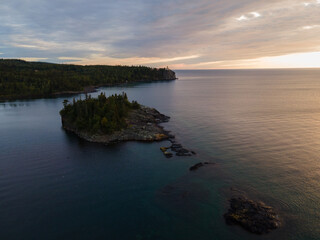 stunning aerial view of Split Rock Lighthouse at sunrise, glowing over Lake Superior’s summer shoreline. Minnesota 
