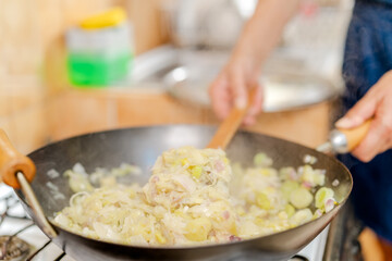 Chef cooking scrambled pores with egg for cake in wok
