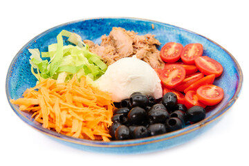 Salad with Buffalo mozzarella, tuna fish, cherry tomatoes, iceberg salad, olives, carrots,  in the blue plate with white background