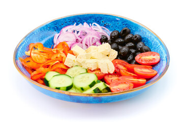 Greek salad with Cherry tomatoes, cucumber, peppers, olives, Greek feta cheese, red onions in the blue plate with white background