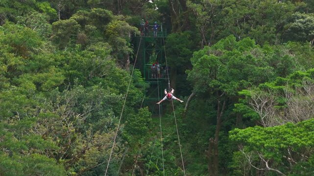 This aerial shot showcases an exhilarating zipline experience soaring through lush canopies in Costa Ricas vibrant ecosystem, surrounded by breathtaking nature and diverse wildlife