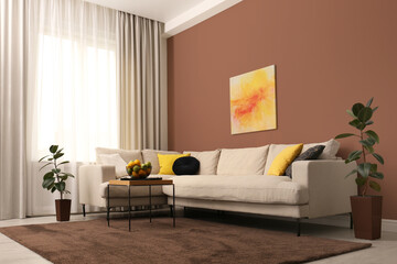Stylish living room with elements in mocha mousse shade. Interior design with trendy color of 2025 year