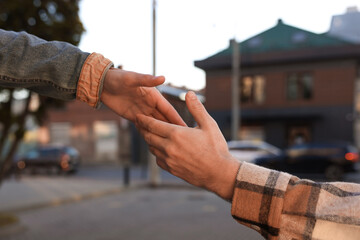 Man offering helping hand to his friend on city street, closeup