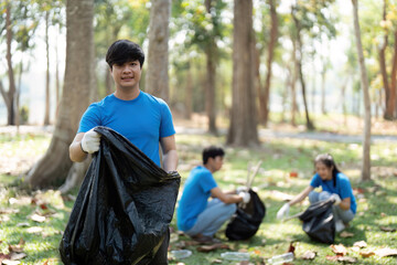 Environmental Stewardship and Team Spirit. A volunteer holding a garbage bag, excited after a...