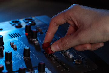 Woman working with professional mixing console at table, closeup