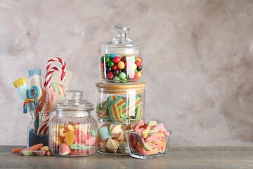 Candy bar. Many different sweets on wooden table against grey background. Space for text