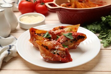 Delicious conchiglie pasta with ricotta cheese, tomato sauce and parsley on wooden table, closeup