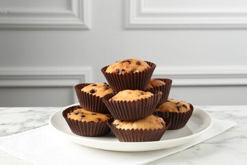 Delicious muffin with chocolate chips on white marble table