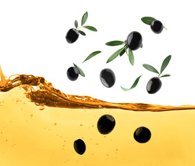 Black olives and green leaves falling into cooking oil on white background
