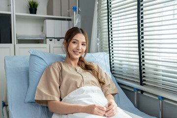 Asian young female patient lying on a hospital bed in recovery room.	
