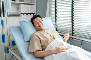 Obraz premium Portrait of young man patient lying on hospital bed in recovery room.