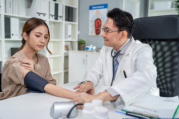Fototapeta premium Asian doctor examine patient woman use blood pressure gauge in hospital. 