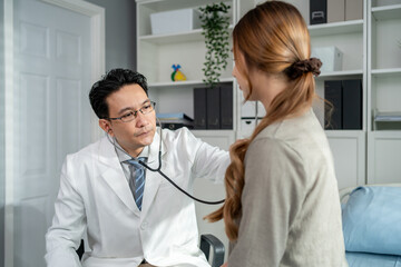 Asian cardiologist doctor listen to heartbeat patient woman in hospital.	
