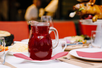 Decanter of berry juice stands on a laid table in a restaurant