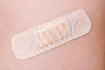 Closeup view of a covered wound with an adhesive plaster