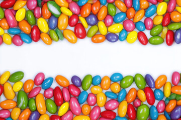 Colorful assortment of candy-coated chocolates scattered on a white surface.