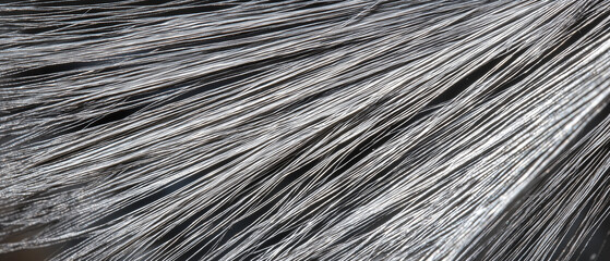 close up macro shot of fine, textured silver strands, showcasing intricate details and metallic sheen. image highlights delicate and fibrous structure of material