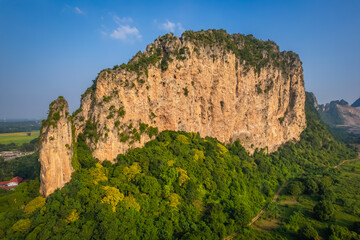 This rocky mountain is called Khao E-Bid, located in Phetchaburi Province, Thailand. It appears...