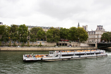 Obraz premium River Cruises sailing bring travelers passengers tour and looking old town Paris city at riverside of Seine river