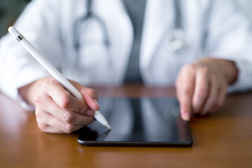 Fototapeta premium Professional healthcare doctor and writing digital records on tablet. Innovative medical consultation, telemedicine patient management and modern healthcare technology.