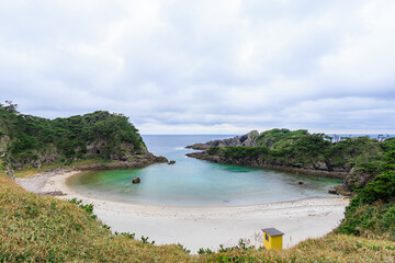 Fototapeta premium 式根島の美しい泊海水浴場と沖を行く東海汽船さるびあ丸。東京都伊豆諸島式根島-2024 