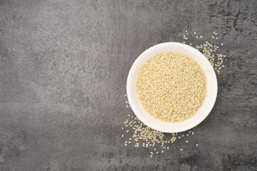 White sesame in a bowl on stone texture background