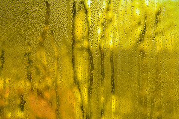 Condensation background on wet yellow glass