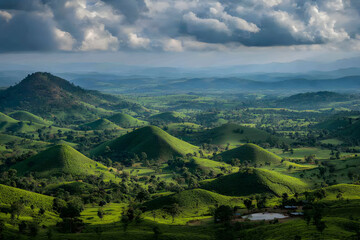 Obraz premium Serene panoramic view of rolling green hills under a dramatic sky, showcasing the beauty of nature's artistry.