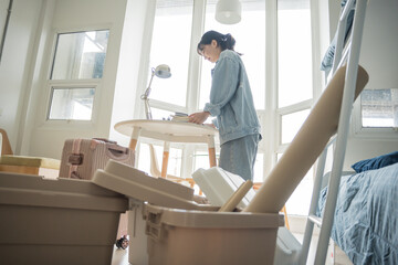 Student asian woman organize room unpack in dorm room college student moving to new  university...