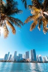 Obraz premium City skyline viewed from beneath palm trees, blue sky, calm water