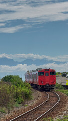 Obraz premium Train Passing Through Amaharashi Coast, Toyama - Distant View of Tateyama Mountains