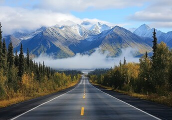 Fototapeta premium Scenic Mountain Road with Lush Green Trees and Misty Valley in Background under Clear Blue Sky