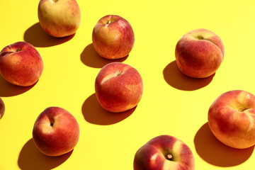 Many sweet peaches on yellow background